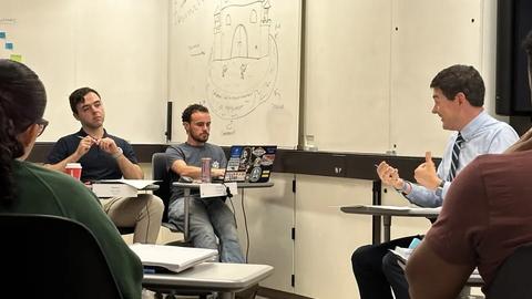 Students listen to a professor speak